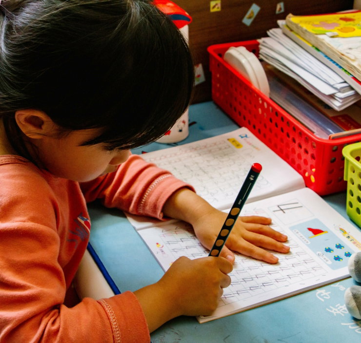 young child writing at a table